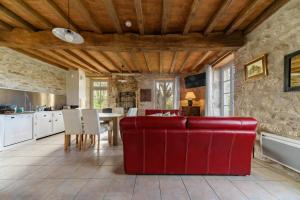 a living room with a red couch and a table at Hameau Grande Varenne - Gites de charme avec piscine in Charroux-dʼAllier +84 photos