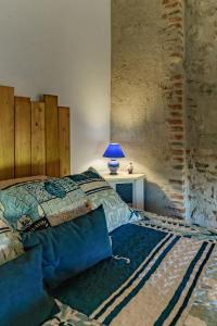a bedroom with a bed and a table with a lamp at Hameau Grande Varenne - Gites de charme avec piscine in Charroux-dʼAllier
