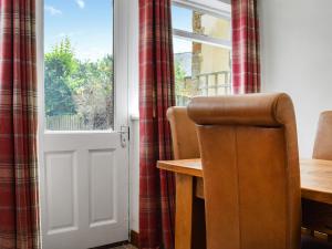 a table and a chair in front of a door at Juniper Cottage in Hook Norton +13 photos