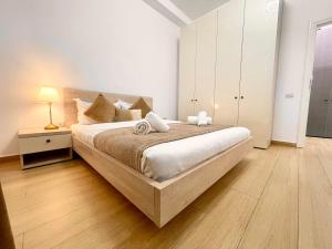 een witte slaapkamer met een groot bed en een nachtkastje bij Central Address 4 - Palace of Parliament Area in Boekarest