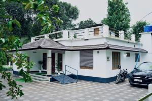 a white house with a car parked in front of it at Nyx Villa in Jāmb