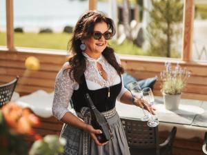 a woman is holding a glass of wine at Alpin Peaks in Turracher Hohe