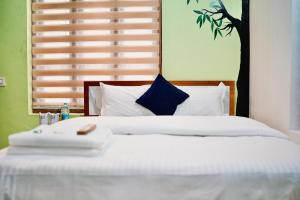 a bedroom with a large white bed with a blue pillow at Nyx Villa in Jāmb