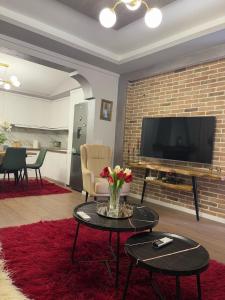 戈里察villa dervishaj的客厅配有电视和鲜花桌