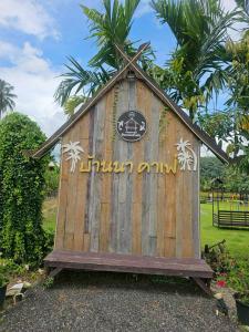 a wooden building with a sign on top of it at Banna Cafe & Glamping บ้านนา คาเฟ่ แอนด์ แกรมปิ้ง in Fang