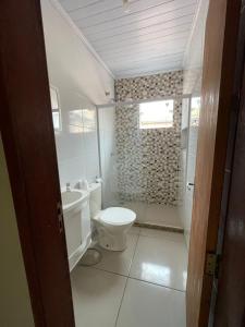 um banheiro branco com vaso sanitário e chuveiro em Cepop Campos 1 em Campos dos Goytacazes