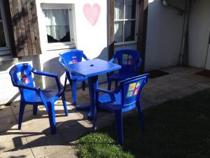 La Petite Maison de La Rochelle في لا روشيل: ثلاثة كراسي زرقاء وطاولة مع طاولة زرقاء