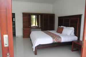 a bedroom with a large bed and a window at Ayuna Cottages in Bedahulu