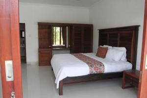 ein Schlafzimmer mit großem Bett und Fenster in der Unterkunft Ayuna Cottages in Bedahulu