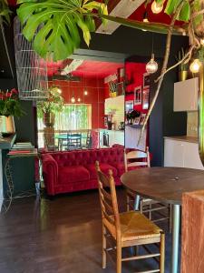 a living room with a red couch and a table at romantic house in Poelkapelle