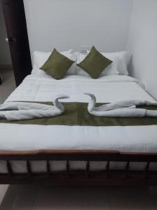 a bed with two swans made out of towels at ETERNA Homestay Rackad in Mūvattupula