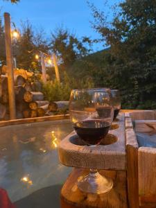 a glass of wine sitting on a table next to a swimming pool at romantic house in Poelkapelle +26 photos