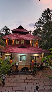 a large house with a patio in front of it at Nostalgia Homestay in Vythiri +30 photos