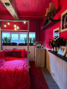 a red bedroom with a bed and a window at Romantic house with hot tub in Poelkapelle