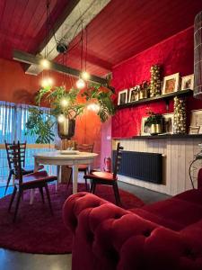 a living room with a table and a red wall at romantic house in Poelkapelle