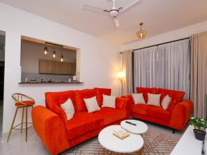 a living room with two red couches and a table at Cosy 2 Bedroom at Ganjoni near the landmark site at Pembe za Ndovu - Elephant Task in Mombasa