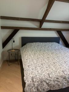a bedroom with a bed and a table at In de olde kapschuur in Beemte