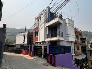 - un bâtiment blanc avec un balcon dans une rue dans l'établissement Bista Niwas, à Bhaktapur