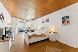 a bedroom with a bed and a wooden ceiling at Lake View Studio 1 - 2 Personen I See - Bergsicht I 40" Smart TV I Dusche, Fahrstuhl und Parkplatz in Ingenbohl