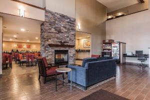 a lobby with a blue couch and a fireplace at Comfort Suites Fort Wayne North in Fort Wayne