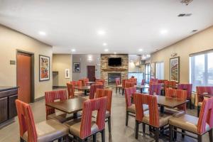 a restaurant with tables and chairs and a fireplace at Comfort Suites Fort Wayne North in Fort Wayne