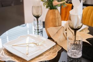 a table with a white plate and a vase of flowers at Deplatinum Luxury Apartment-A Home away with love in Sandton