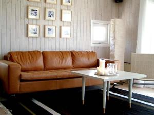 een woonkamer met een bruine bank en een tafel bij 6 person holiday home in Dronningmølle-By Traum in Hornbæk +18 foto's