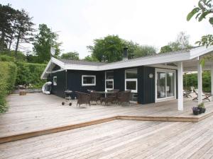 een huis met een terras met een tafel en stoelen bij 6 person holiday home in Dronningmølle-By Traum in Hornbæk