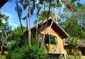ein Haus mit Palmen davor in der Unterkunft The Moon Rabbit Resort Pai in Pai