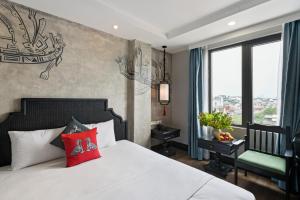 a bedroom with a white bed with red pillows at Hanoi Indochine Premium Hotel in Hanoi +64 photos