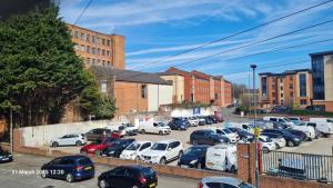 ein Parkplatz voller Autos in einer Stadt in der Unterkunft 2 Bed Ensuite, Secure Parking, Fast WiFi & SmartTV in Derby