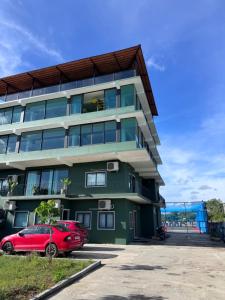 a red car parked in front of a building at Turiya Retreat in Auroville