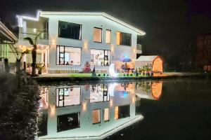 een huis met een reflectie in het water 's nachts bij 7star in Guilin
