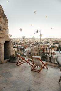 a patio with two chairs and a view of a city at Paradise Cappadocia Hotel in Goreme