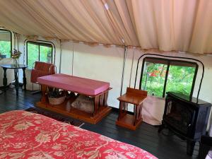 une chambre avec un lit, une table et une télévision dans l'établissement Cozy Tented Cabin Rental near the Hudson River in Upstate New York, à North River 29 autres photos