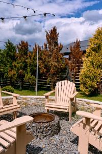 Dos sillas alrededor de una fogata en un patio. en stream housee, en Slavske