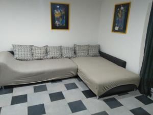 een bank in een kamer met een geruite vloer bij Appartement Rdc in Wawern +1 foto