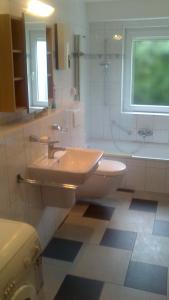 een badkamer met een wastafel en een toilet en een raam bij Appartement Rdc in Wawern