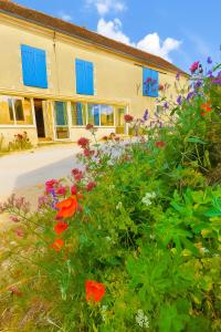 ein Gebäude mit bunten Blumen davor in der Unterkunft Location de Chambres Bienvenue chez Mémé in Treigny