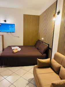 een slaapkamer met 2 bedden en een bank bij Hello Verona Rooms in Verona