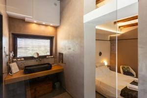 une chambre avec un lit, un lavabo et une fenêtre dans l'établissement 18Th Century Farmhouse In Racalmuto Countryside, à Grotte 32 autres photos