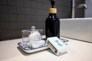 a bathroom counter with a bottle of soap and a soap bar at Stylish OceanBreeze 50 Central Mossel Bay in Mossel Bay