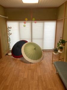 a room with two umbrellas on the floor at ヴィラこんぴら Villa Konpira in Kotohira