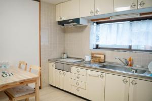 a small kitchen with a sink and a table at ヴィラこんぴら Villa Konpira in Kotohira