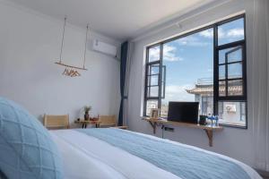 una camera da letto con un letto e una grande finestra di Dali Linghaoyun Homestay a Dali