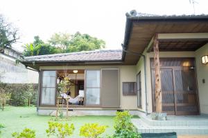 a person sitting in the window of a house at ヴィラこんぴら Villa Konpira in Kotohira