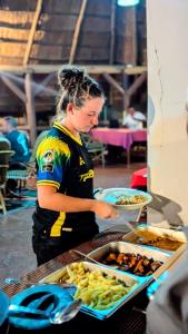 a woman standing in front of a buffet of food at LIMAS Camp Mikumi in Mikumi