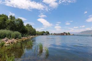 un fiume con rocce e una casa in lontananza di Dali Linghaoyun Homestay a Dali