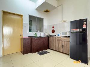 タイピンにあるTaiping Crystal Creek Condo Pool Gym Netflix 8-9PAXの木製のキャビネットと黒い冷蔵庫を備えたキッチン