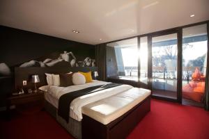 een slaapkamer met een groot bed en een groot raam bij MONA Pavilions in Hobart +39 foto's